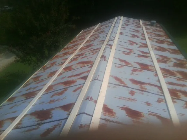 Rusted metal roof panels with new wood purlins before replacement — Storm Damage Roof Repair in Barbourville by Roofing Brothers