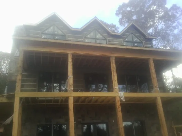 Dormers and porch framing on a large log home under construction — Roof Coating work by our crew in Barbourville