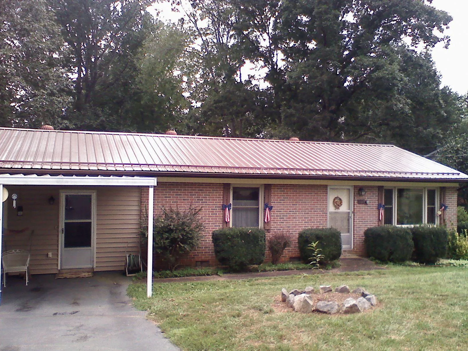 Bronze metal roof and carport on a brick ranch home — Roof Repair work by our crew in Barbourville